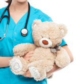 Une infirmière avec un stéthoscope qui tient un ourson pour le cours PALS